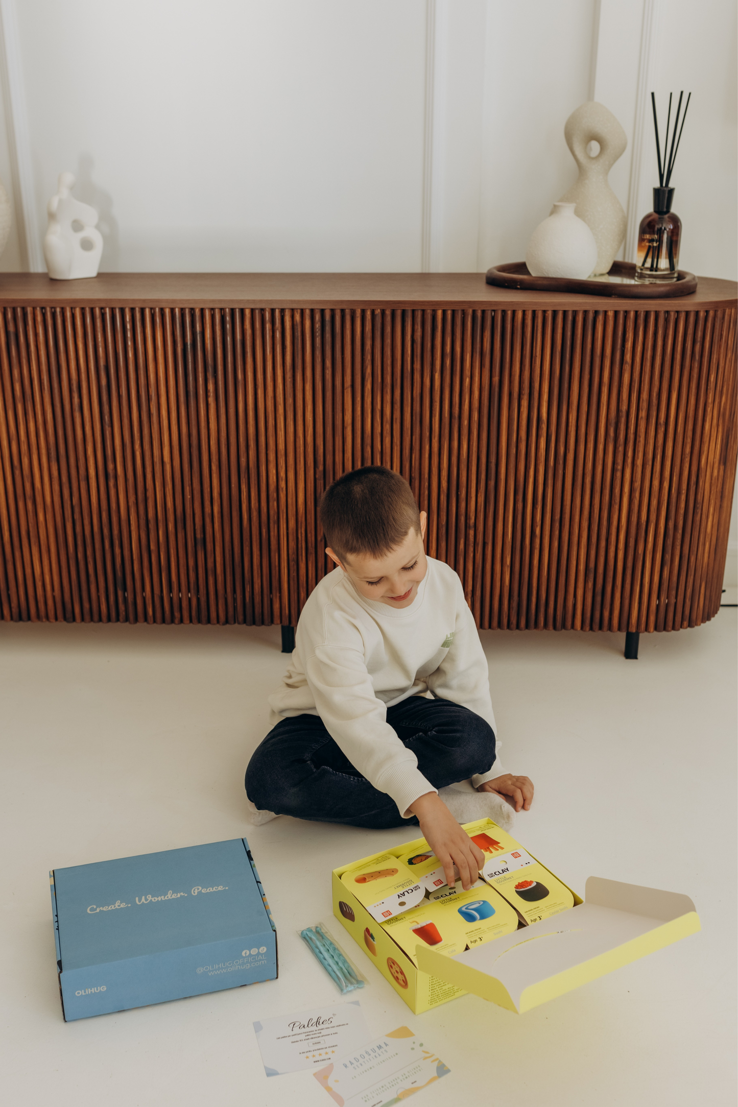Joyful child smiling while shaping bright clay figures from the OLIHUG clay kit. A Montessori-inspired, mindful play experience loved by parents for its calming, educational, and bonding energy. Creates transformation from screen stress to shared creative peace. Ideal for conscious families and gift-givers.
