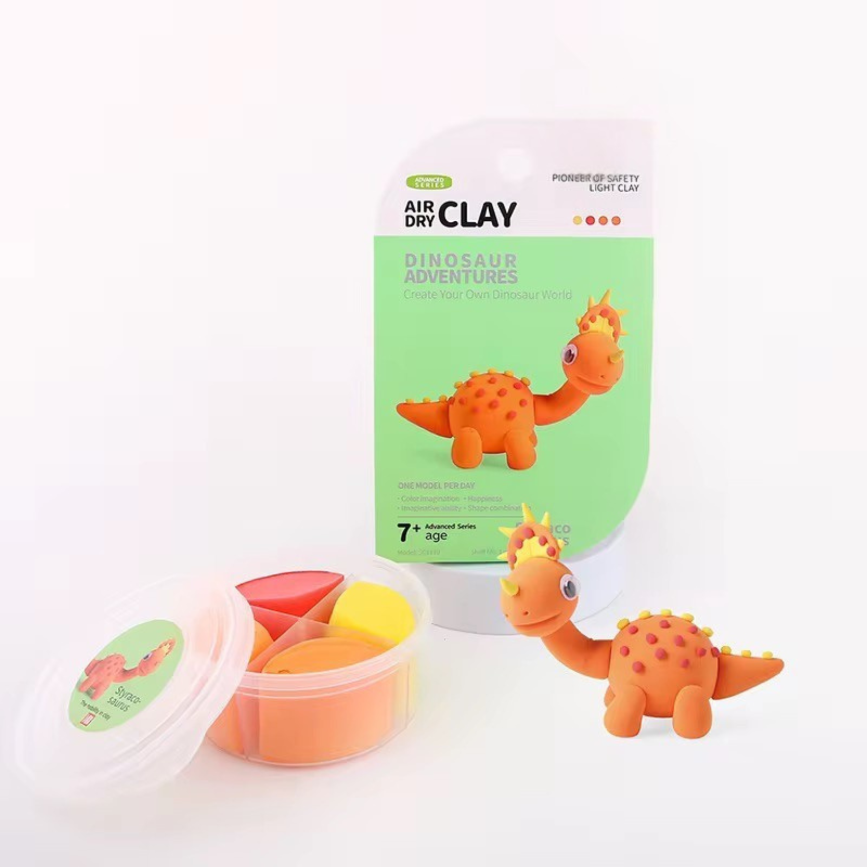 Bright orange dinosaur clay model beside yellow and pink air-dry clay tubs. Simple sculpting activity builds concentration and fine motor skills through fun.