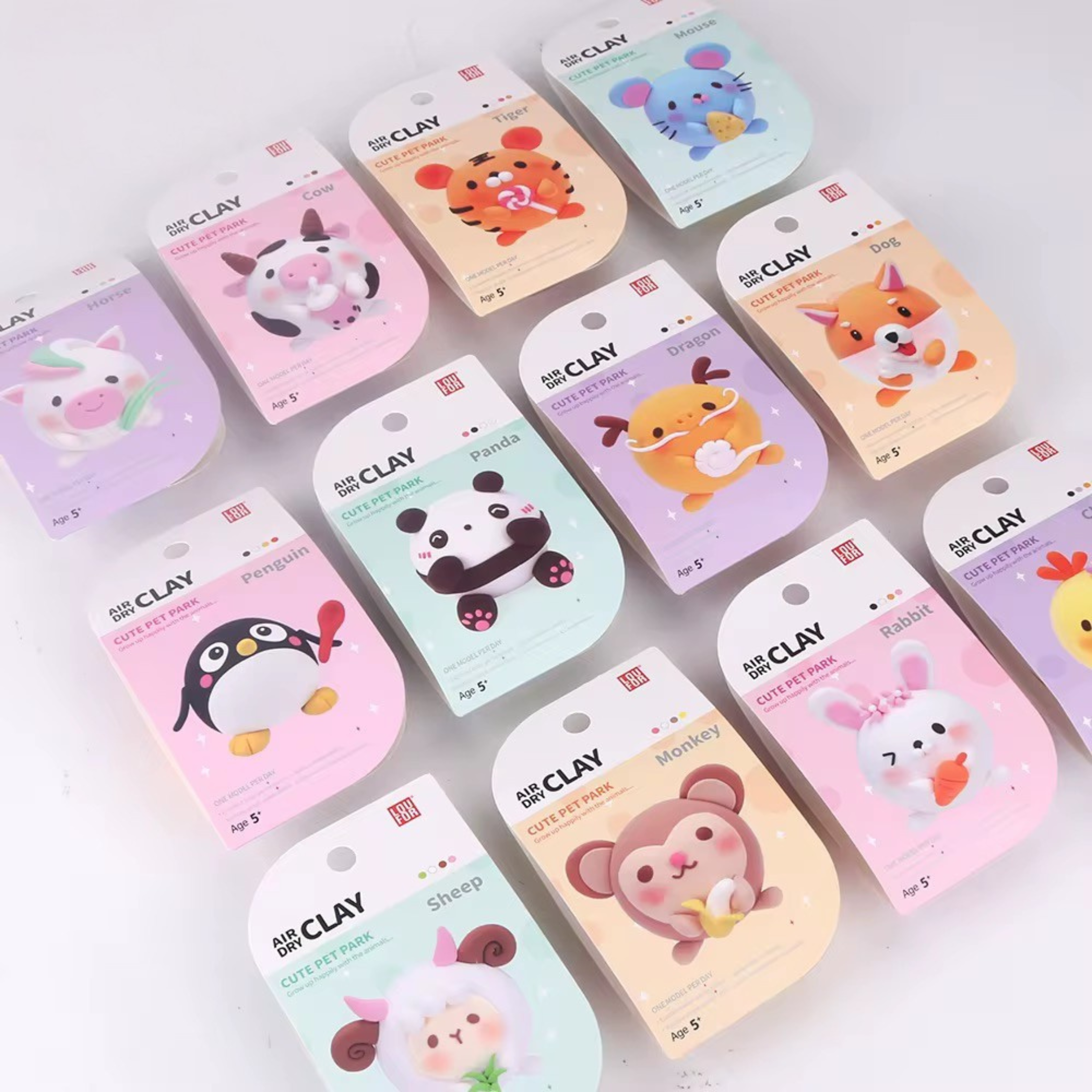 Colorful collection of themed air dry clay sets for kids displayed on shelf. Showcases the packaging variety for Pet Park animals. Suitable for resale or gifting options.