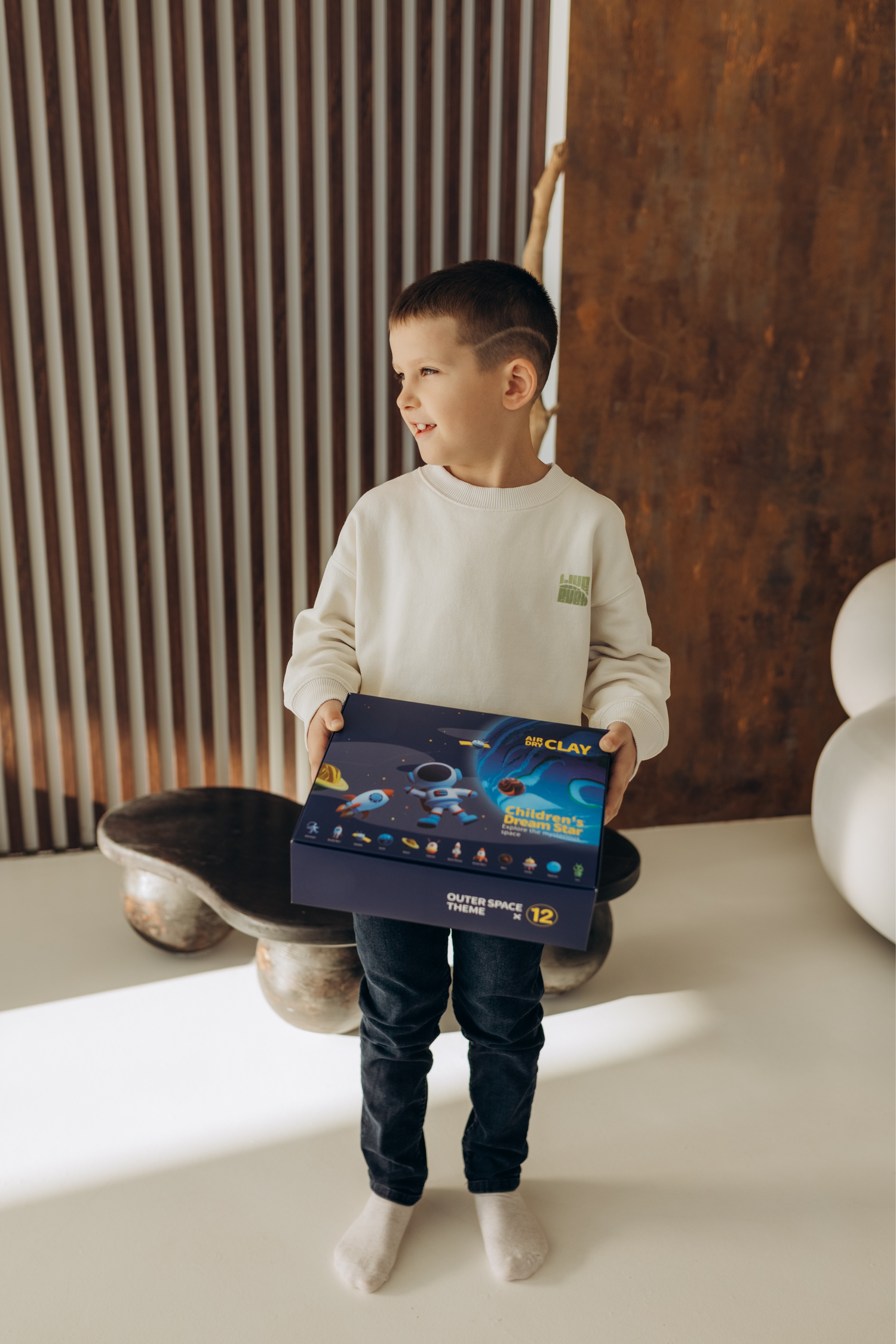 Child holding an air-dry clay kit at home, screen-free creative activity for kids, promoting calm focus, imagination, fine motor skills and mindful play for modern families.